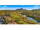 Aerial view of a home with a nearby golf course and lake, plus mountain backdrop at 7424 N Via Camello Del Norte -- # 185, Scottsdale, AZ 85258