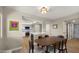 Open dining room featuring wood floors, stylish lighting, and views to the updated kitchen at 7424 N Via Camello Del Norte -- # 185, Scottsdale, AZ 85258