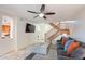 Cozy living room featuring tile floors, ceiling fan, mounted TV, and wooden staircase at 8414 N Central Ave # C, Phoenix, AZ 85020