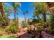 Beautifully landscaped backyard with brick pathways, mature trees, and serene water fountain at 8540 W Wescott Dr, Peoria, AZ 85382