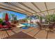 Inviting pool area with shaded pergola, lounge chairs, and well-maintained landscaping at 8540 W Wescott Dr, Peoria, AZ 85382