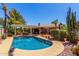 Backyard pool area featuring a covered patio, palm trees, and desert landscaping at 8540 W Wescott Dr, Peoria, AZ 85382