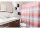 A stylish bathroom features a sleek vanity, modern fixtures, tasteful wall decor, and a colorful shower curtain at 8566 N 110Th Ave, Peoria, AZ 85345