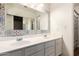 Bathroom with double sink vanity, decorative mirror, and patterned shower curtain at 8566 N 110Th Ave, Peoria, AZ 85345