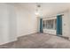 Spacious bedroom features plush carpet, vaulted ceilings, and bright window with curtains at 8566 N 110Th Ave, Peoria, AZ 85345