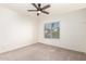 A blank canvas bedroom features neutral carpeting, paint, a modern ceiling fan, and a window with blinds at 8566 N 110Th Ave, Peoria, AZ 85345