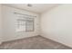 An empty bedroom with neutral paint, carpet, and a window with blinds allows for personalized design at 8566 N 110Th Ave, Peoria, AZ 85345