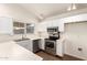Updated kitchen showcases stainless steel appliances, white cabinets and countertops, and wood flooring at 8566 N 110Th Ave, Peoria, AZ 85345