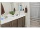 The bathroom has double sinks and wood cabinets with a shower/tub combo for a practical design at 10236 W Wood St, Tolleson, AZ 85353