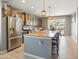 Open kitchen with stainless steel appliances, an island with seating, and sliding glass doors to the backyard at 10236 W Wood St, Tolleson, AZ 85353