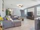 Bright living room featuring a comfortable gray sofa, tile floors, and an entertainment center at 10236 W Wood St, Tolleson, AZ 85353