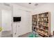 Bedroom features large bookshelf, mounted television, and white closet doors at 12505 W Kaler Dr, Glendale, AZ 85307