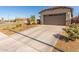 Home featuring a long driveway and a two-car garage, complete with desert landscaping for low maintenance at 12505 W Kaler Dr, Glendale, AZ 85307