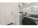 Clean, organized laundry room with modern washer and dryer appliances and shelving at 12505 W Kaler Dr, Glendale, AZ 85307