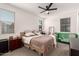 Tranquil main bedroom featuring a ceiling fan, plush carpeting, and ample natural light from the well placed windows at 12505 W Kaler Dr, Glendale, AZ 85307