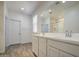 Bright bathroom featuring a double vanity, a window, and wood-look tile flooring at 12515 W Marguerite Ave, Avondale, AZ 85323