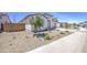 A side view of a single-story home with desert landscaping, shrubs, and a brick fence at 12515 W Marguerite Ave, Avondale, AZ 85323