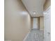Bright hallway with wood-style tile floors leading to a white front door and bedrooms at 12515 W Marguerite Ave, Avondale, AZ 85323