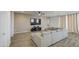Living room featuring wood-style tile floors, a sectional sofa, and a large wall-mounted TV at 12515 W Marguerite Ave, Avondale, AZ 85323