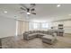 Open-concept living room featuring wood-style tile floors and a large sectional sofa at 12515 W Marguerite Ave, Avondale, AZ 85323