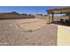 Large backyard with gravel and potential for landscaping or outdoor activities; covered patio with furniture at 13037 W Laurel Ln, El Mirage, AZ 85335
