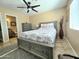 Bedroom with stylish grey bed, ceiling fan, and ensuite bathroom at 13037 W Laurel Ln, El Mirage, AZ 85335