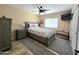 Bedroom with stylish gray bed, ceiling fan and tile floor at 13037 W Laurel Ln, El Mirage, AZ 85335