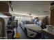 A car parked inside of a spacious garage with storage solutions, shelves, and ample room at 13037 W Laurel Ln, El Mirage, AZ 85335