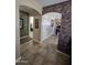 Hallway featuring decorative arches leading to bedroom and office space at 13037 W Laurel Ln, El Mirage, AZ 85335