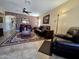 Inviting living room featuring tile flooring, decorative wallpaper, and plush leather sofas at 13037 W Laurel Ln, El Mirage, AZ 85335