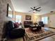 Comfortable living room featuring tile flooring, decorative wallpaper, and plush leather sofas at 13037 W Laurel Ln, El Mirage, AZ 85335