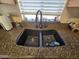 Close-up of modern kitchen sink with black faucet and granite counter at 13037 W Laurel Ln, El Mirage, AZ 85335