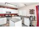 Bright kitchen with white cabinets, stainless steel appliances, island, and stylish gray countertop at 1376 E Rosemary Trl, Casa Grande, AZ 85122