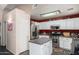 Well-equipped kitchen with stainless steel appliances, white cabinetry, and a practical kitchen island at 1376 E Rosemary Trl, Casa Grande, AZ 85122