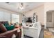 A spacious living room featuring a ceiling fan, comfortable seating, and ample natural light at 1376 E Rosemary Trl, Casa Grande, AZ 85122