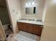 Bathroom featuring a vanity with wooden cabinets, neutral countertops, and decorative mirror at 13857 N 108Th Dr, Sun City, AZ 85351