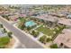 The aerial view showcases a neighborhood pool, barbecue, and green space nestled among single Gathering homes at 14075 W Desert Flower Dr, Goodyear, AZ 85395