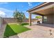 Well maintained backyard featuring a patch of artificial grass, a shade tree, and a covered patio with a hot tub at 14075 W Desert Flower Dr, Goodyear, AZ 85395