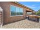 Exterior shot of a backyard showcasing a hot tub, rock landscaping, modern windows, and a covered patio at 14075 W Desert Flower Dr, Goodyear, AZ 85395