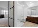 A modern bathroom featuring a glass shower, soaking tub, dark wood vanity, and tile flooring at 14075 W Desert Flower Dr, Goodyear, AZ 85395