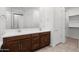 A bathroom with double sink vanity, a large mirror, and a door to the walk-in closet at 14075 W Desert Flower Dr, Goodyear, AZ 85395