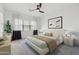 Bright bedroom with a ceiling fan, stylish decor, and a large window for natural light at 14075 W Desert Flower Dr, Goodyear, AZ 85395