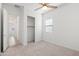 Bright bedroom with neutral carpet, a ceiling fan, and a closet with sliding doors at 14075 W Desert Flower Dr, Goodyear, AZ 85395