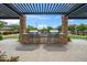 Stone outdoor kitchen with stainless grills and sink in community at 14075 W Desert Flower Dr, Goodyear, AZ 85395