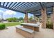Stone outdoor kitchen and picnic area with stone benches and pergola in community at 14075 W Desert Flower Dr, Goodyear, AZ 85395