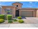 Charming single-Gathering home featuring desert landscaping, a tile roof, and a two-car garage at 14075 W Desert Flower Dr, Goodyear, AZ 85395