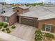 Aerial view of a home with neutral stucco, a tile roof, a driveway, and green shutters at 14075 W Desert Flower Dr, Goodyear, AZ 85395