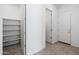 Bright hallway with multiple doors and a storage room with shelving at 14075 W Desert Flower Dr, Goodyear, AZ 85395