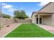 Private backyard features brick-paved patio and synthetic grass lawn at 1410 S Boulder St # A, Gilbert, AZ 85296