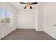 A well-lit room features wood-look tile floors, a ceiling fan, and a large window at 1410 S Boulder St # A, Gilbert, AZ 85296
